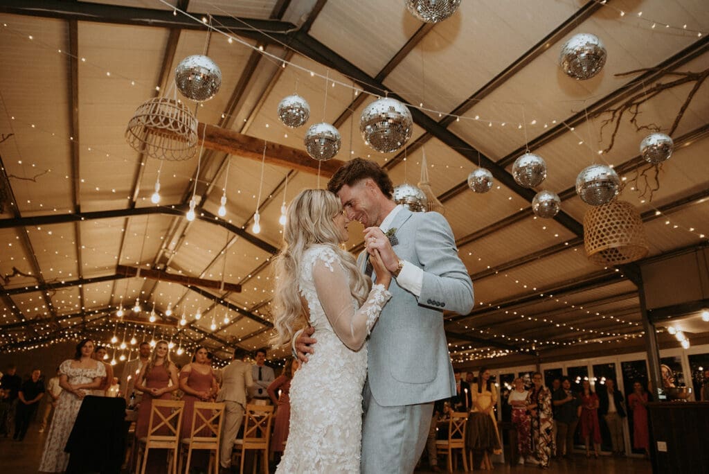Image of bride and groom dancing together romantically during first dance. Image is taken from below eye level.