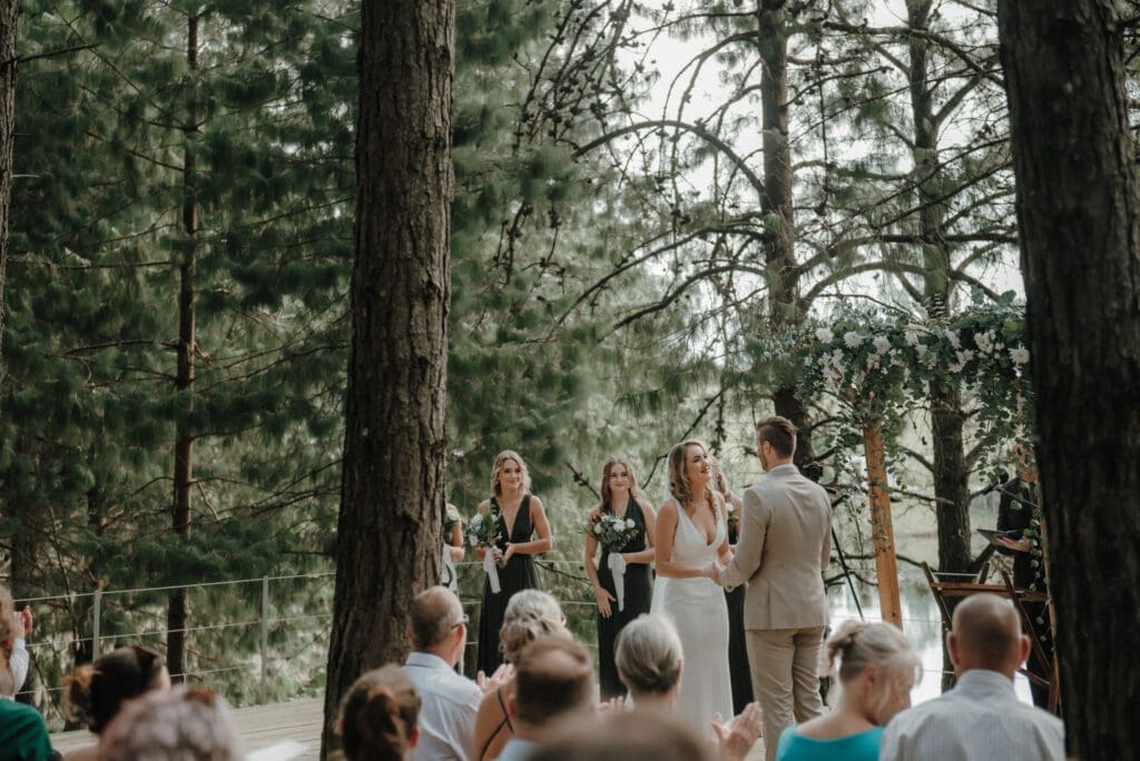 Forest ceremony image showing bride and groom and bridesmaids.