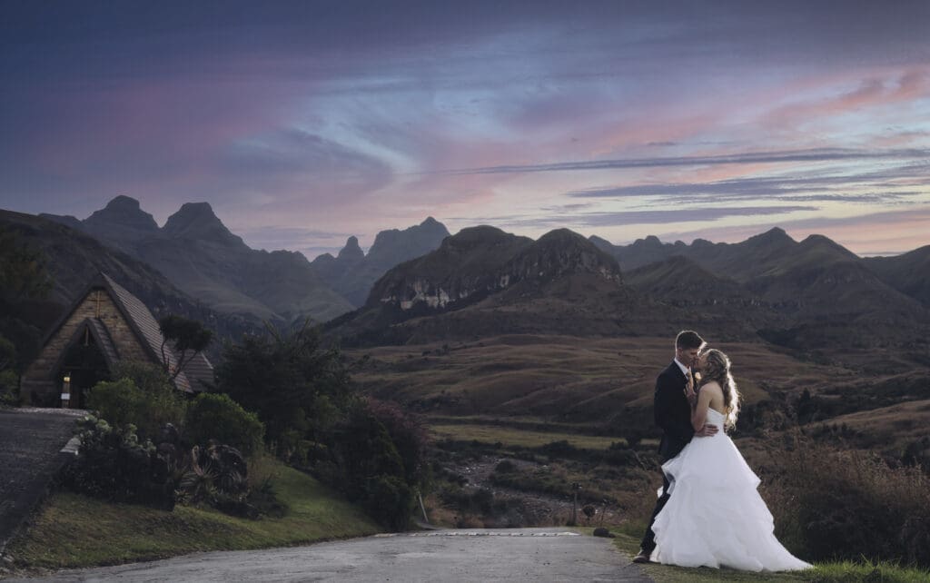 Couple with mountain backdrop and chapel on the left
