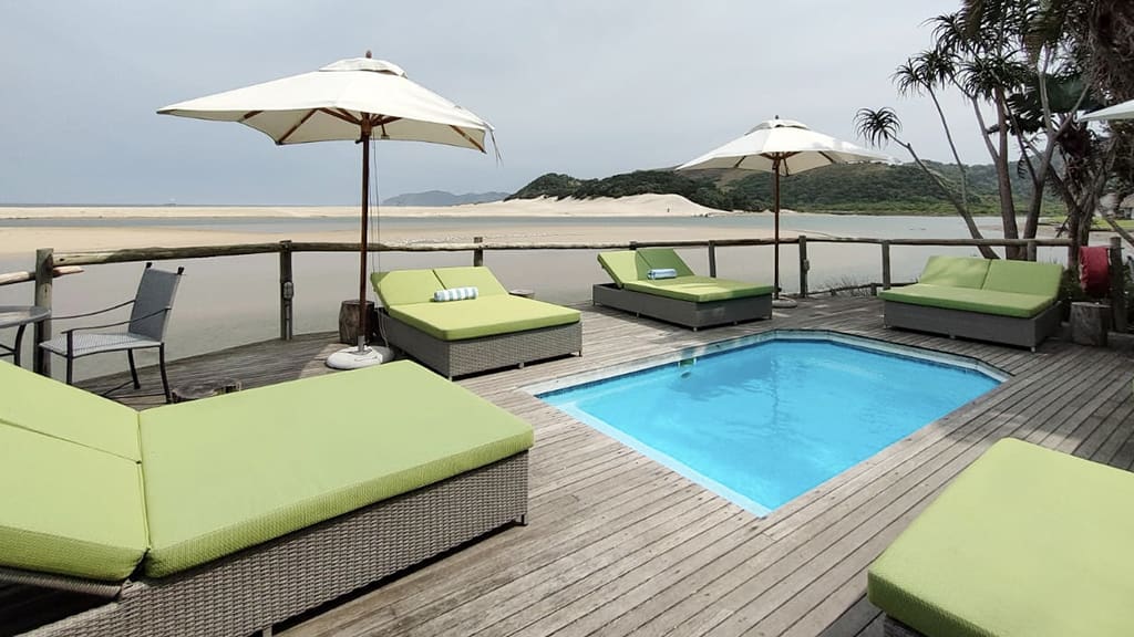 Pool deck with loungers and green cushions