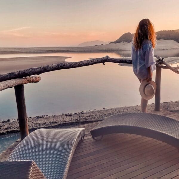 Woman standing on deck overlooking lagoon at Umngazi