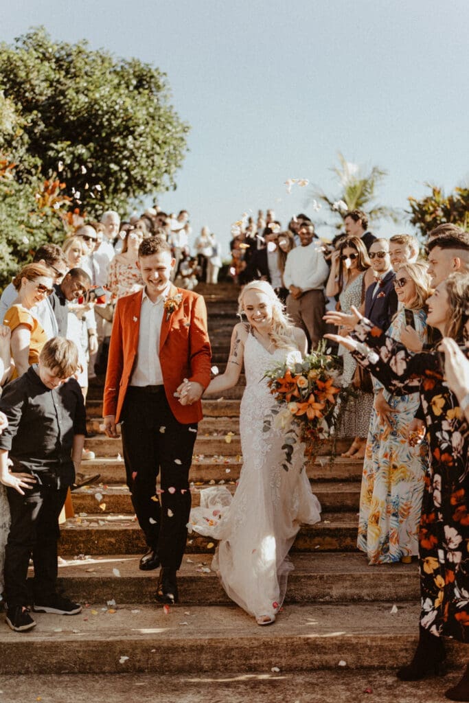 Petal toss over bride and groom as they walk down the staircase.