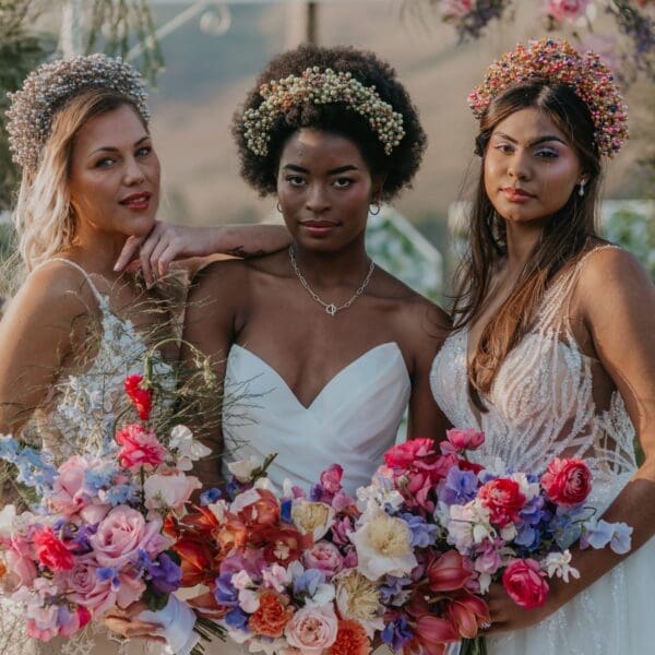 White, African and Indian bride models holding bouquets