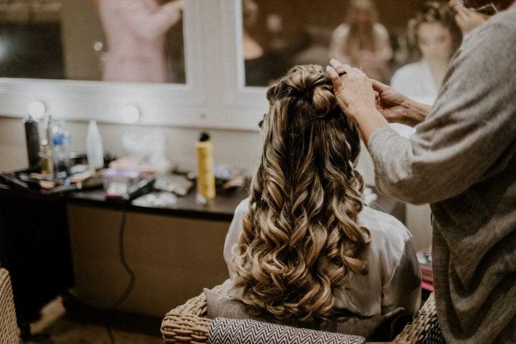 Hair stylist curling bride's hair