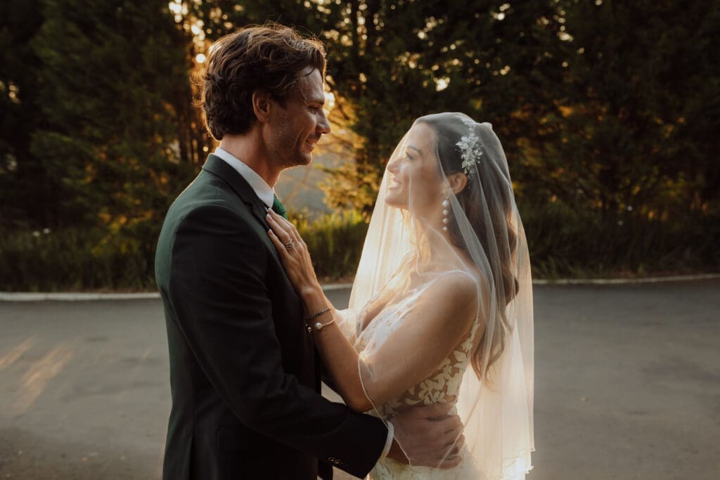 Bride and groom gazing into each others eyes. Bride with veil over her head.
