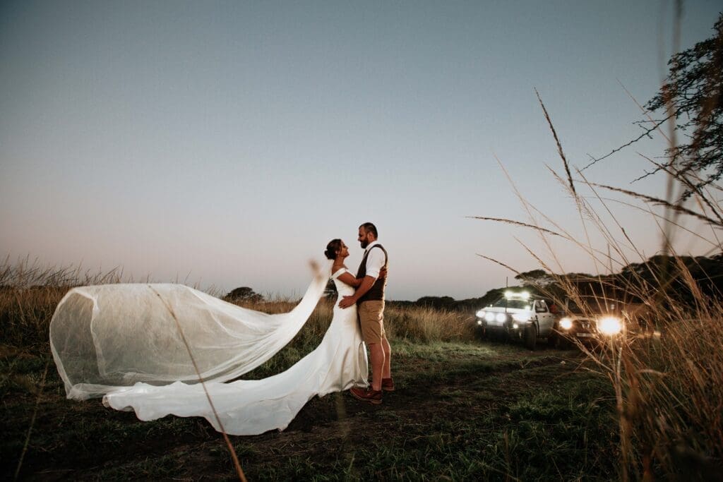 Bride and groom in game reserve at sunset