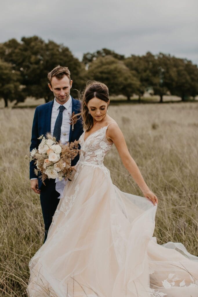 Bride and groom walking with bride holding bouquet