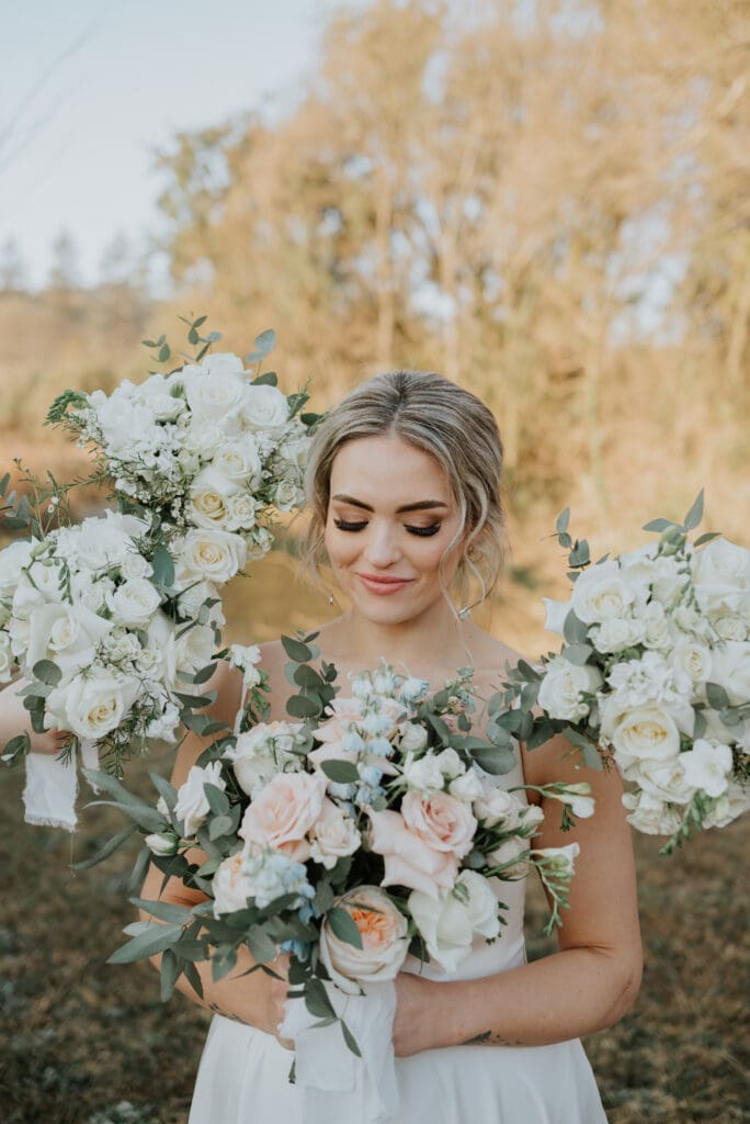 Close-up of bride's face surrounded by bridesmaid bouquets