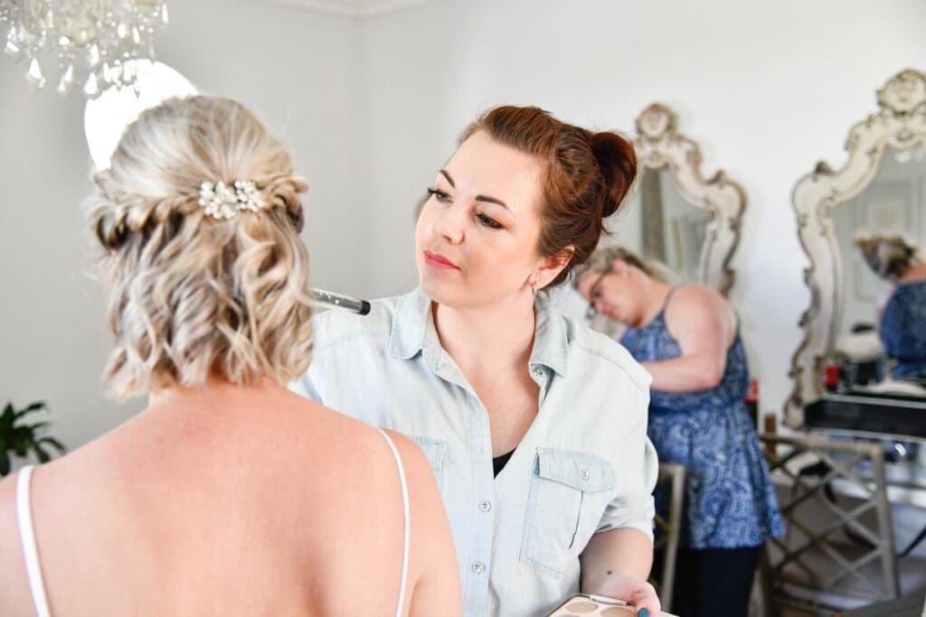 make-up artist working on bridewith short blonde hair