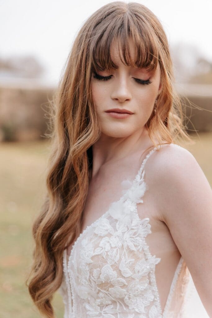 Redheaded bride with natural looking make-up and loose curls in hair