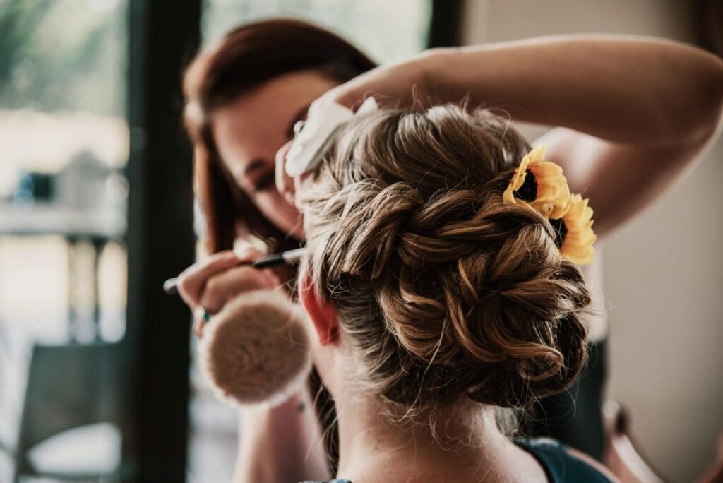 Make-up artist applying blusher to bride's face