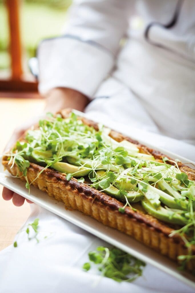 Chef holding pastry dish topped with greens