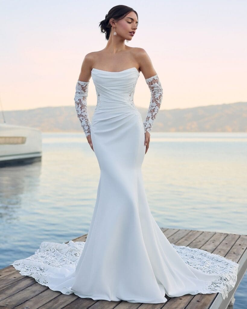 Model wearing strapless and tight fitted wedding down with separate lace sleeves