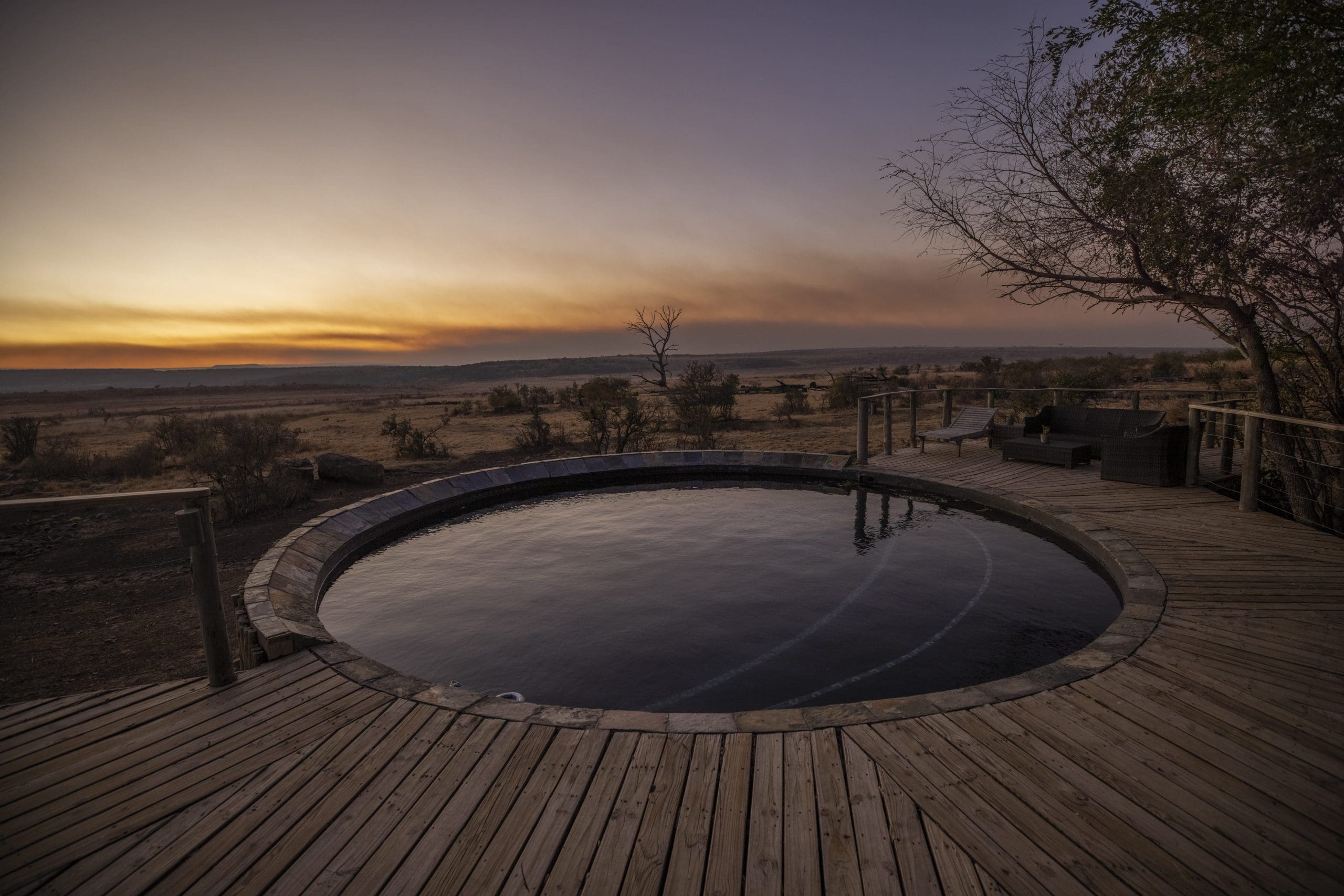 View of circular pool with sun almost set