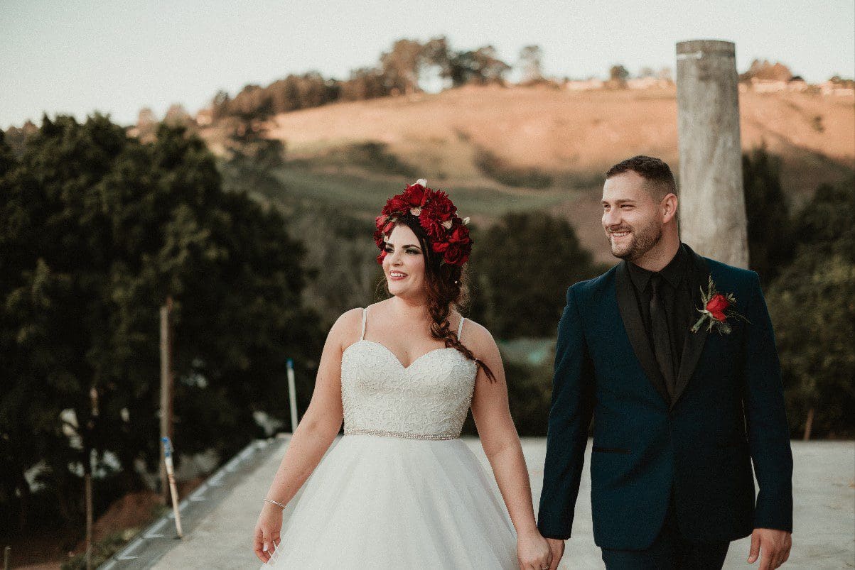 Boho couple holding hands red flower crown