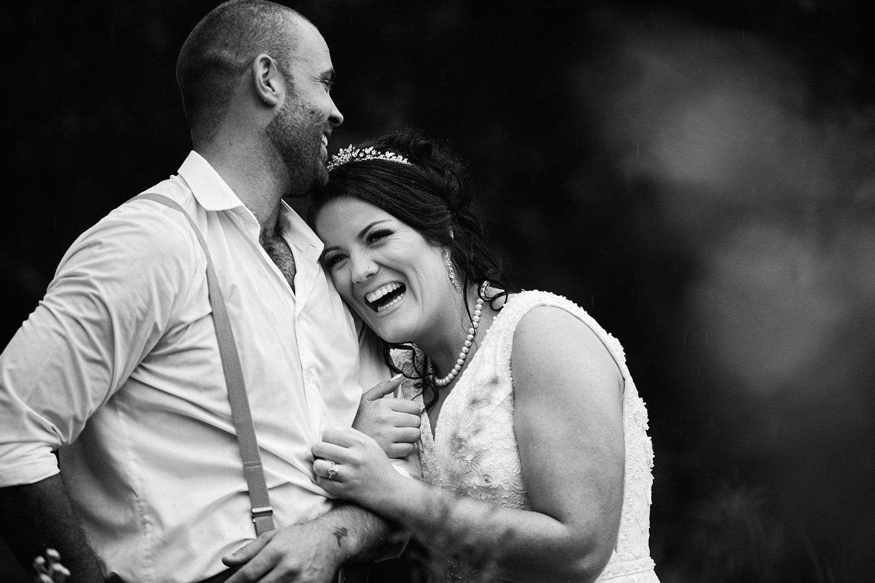 Bride luaghing and resting head on groom's shoulder