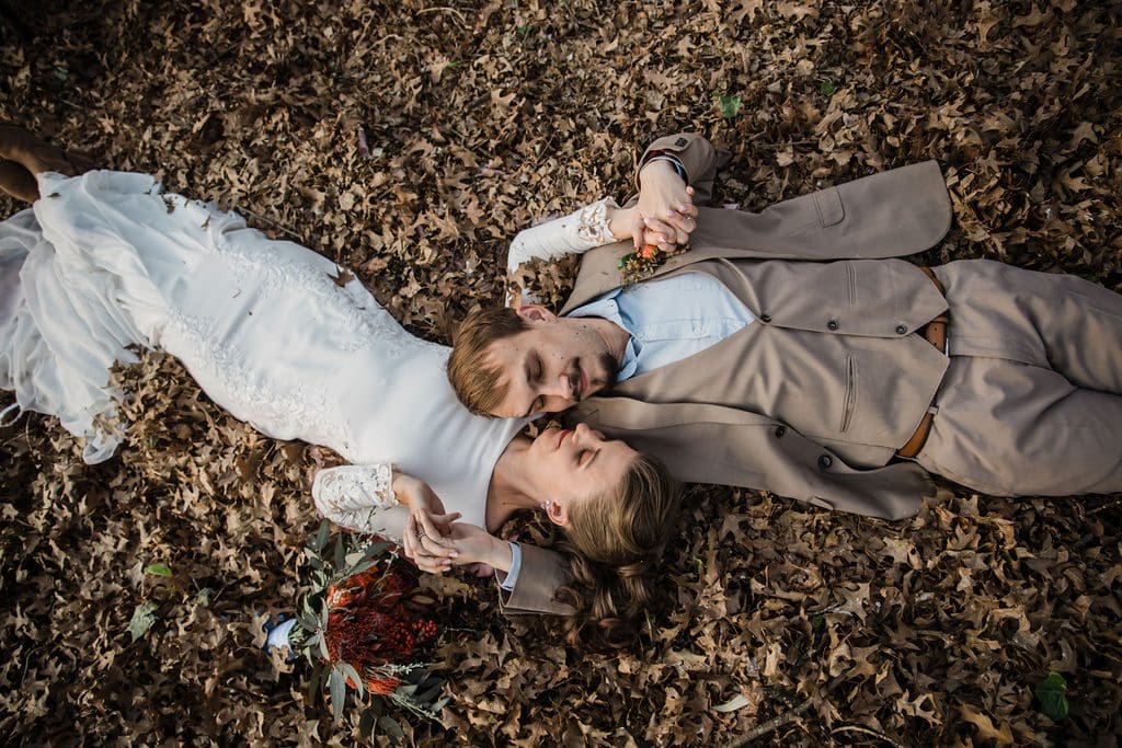 Overhead shot of couple lying in autumn leaves