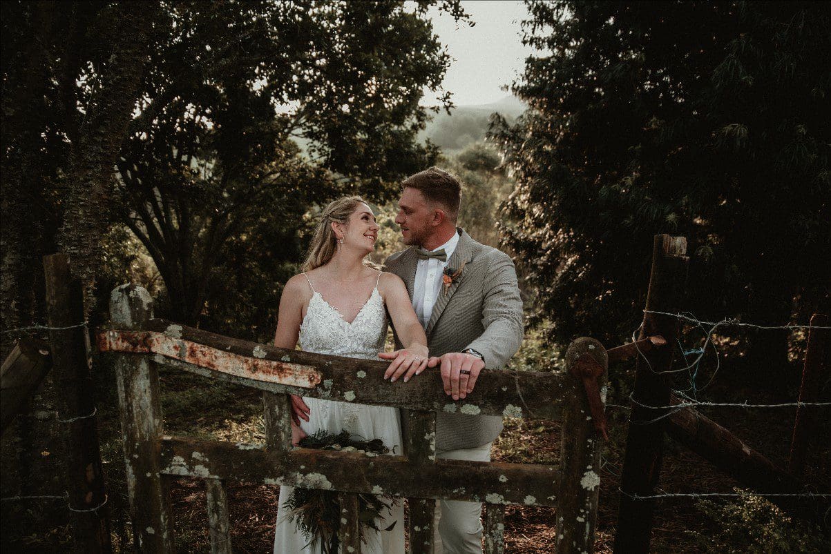Photo of couple's rings with hands on fence