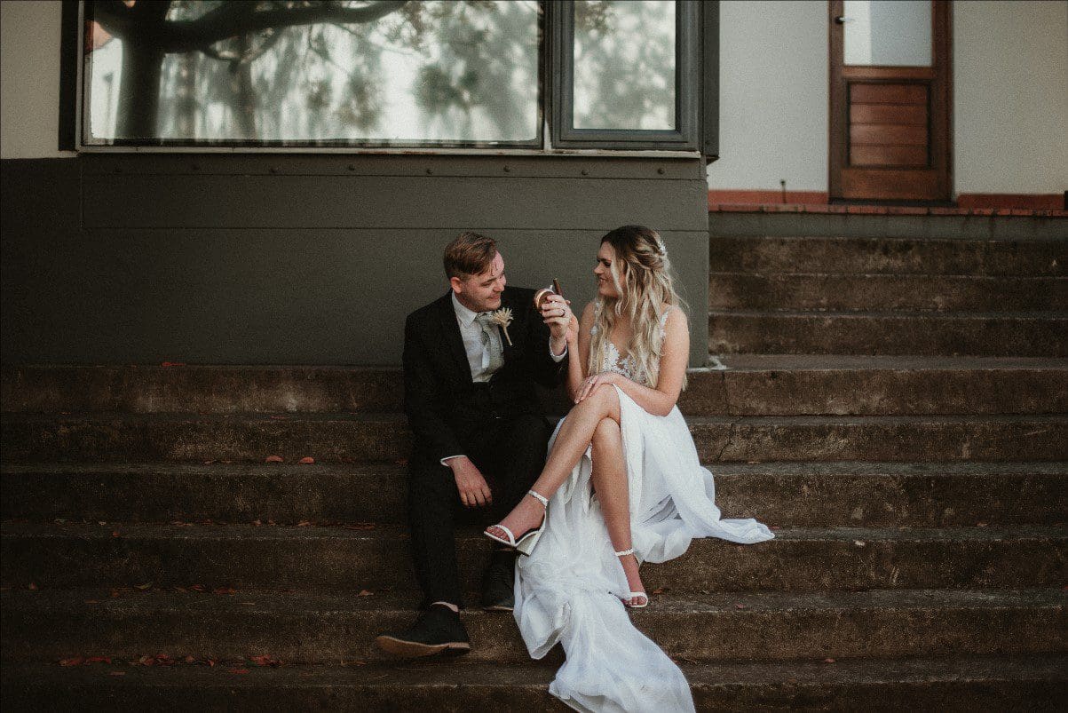 Newly weds sitting on stairs outside building