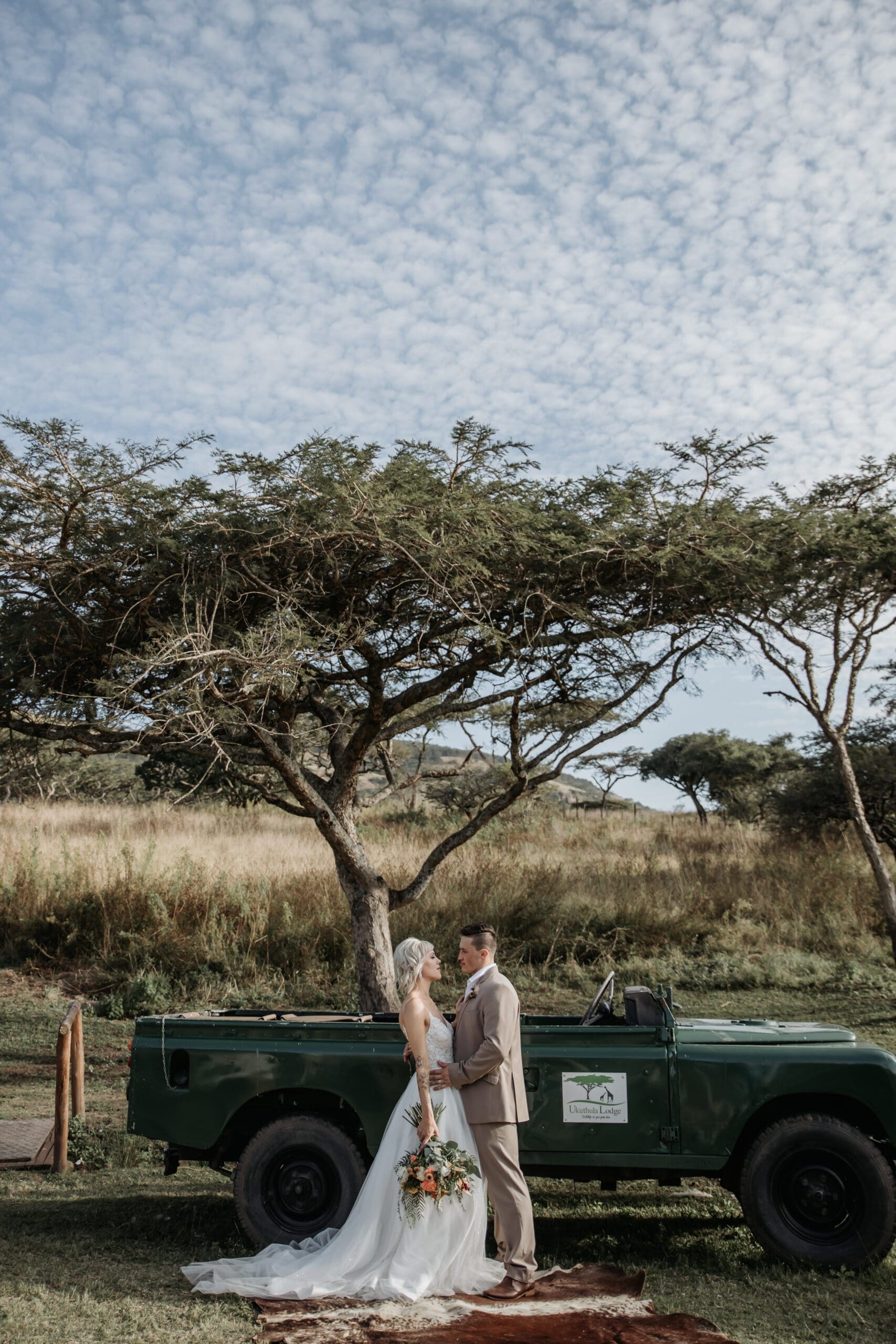 Bridal couple in front of game viewing vehicle