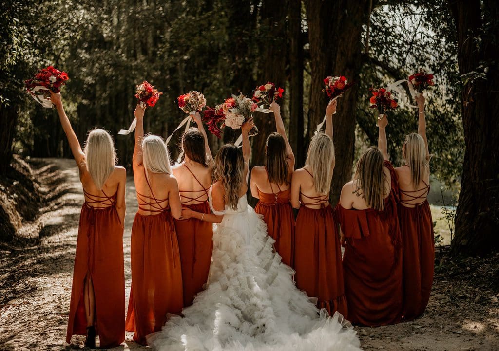 Bride with bridesmaids wearing burnt orange dresses