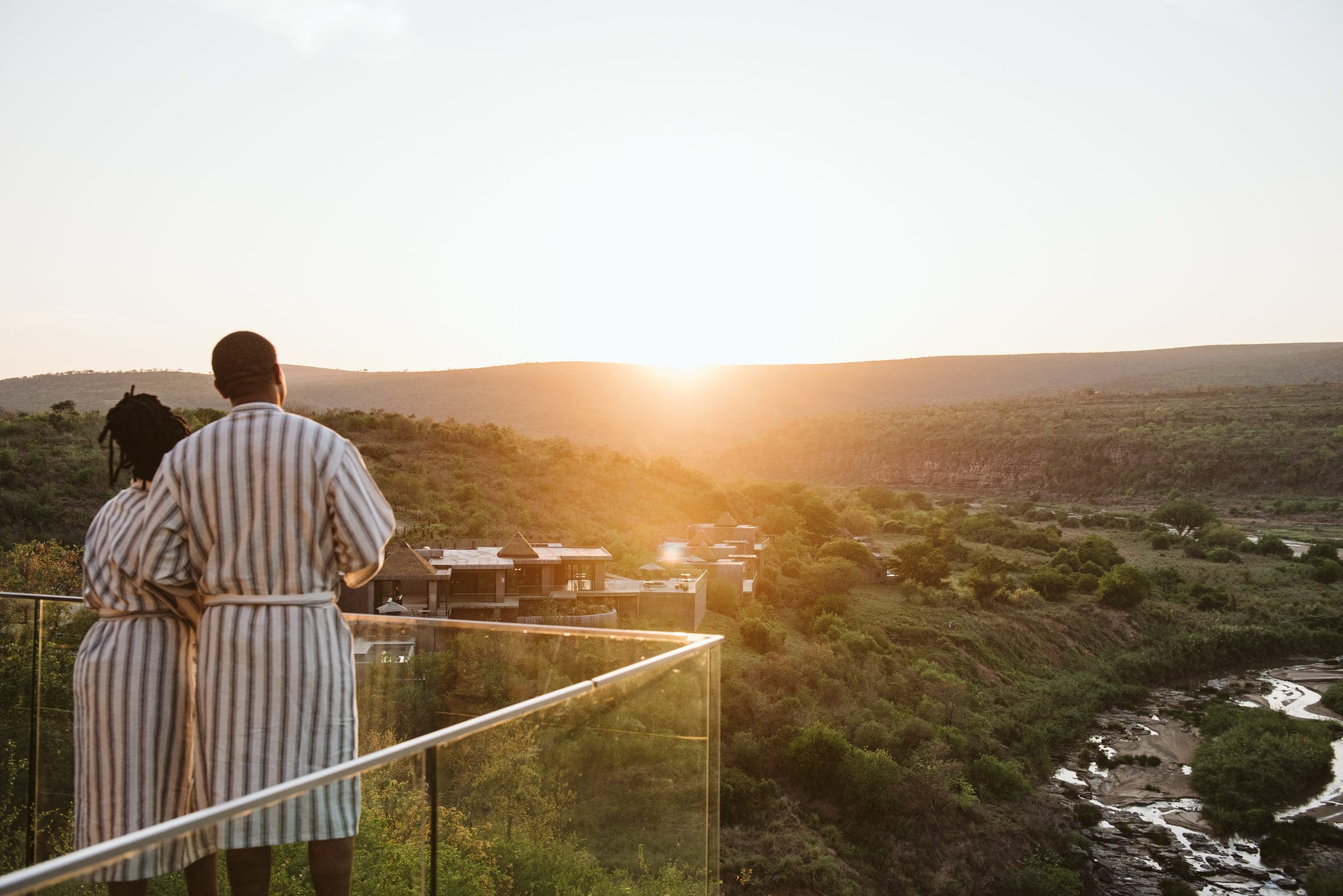 Couple standing on deck overlooking lush bush