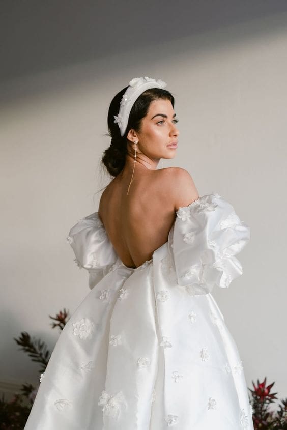 Brunette bride wearing puff sleeve wedding dress and headband
