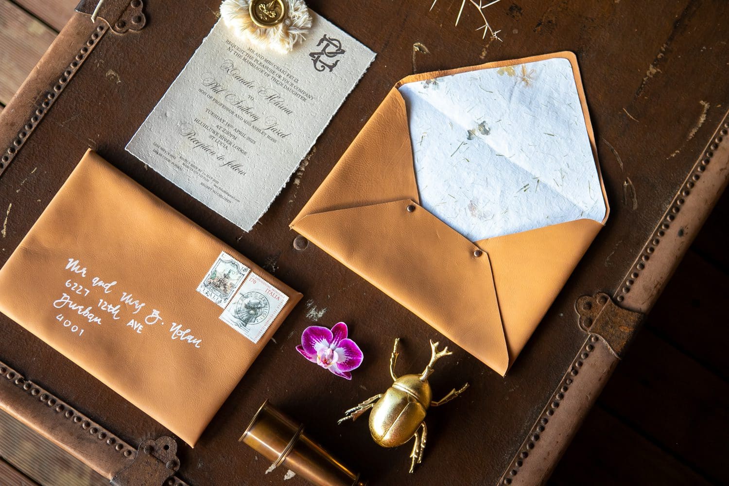Leather wedding stationery details arranged in flat lay