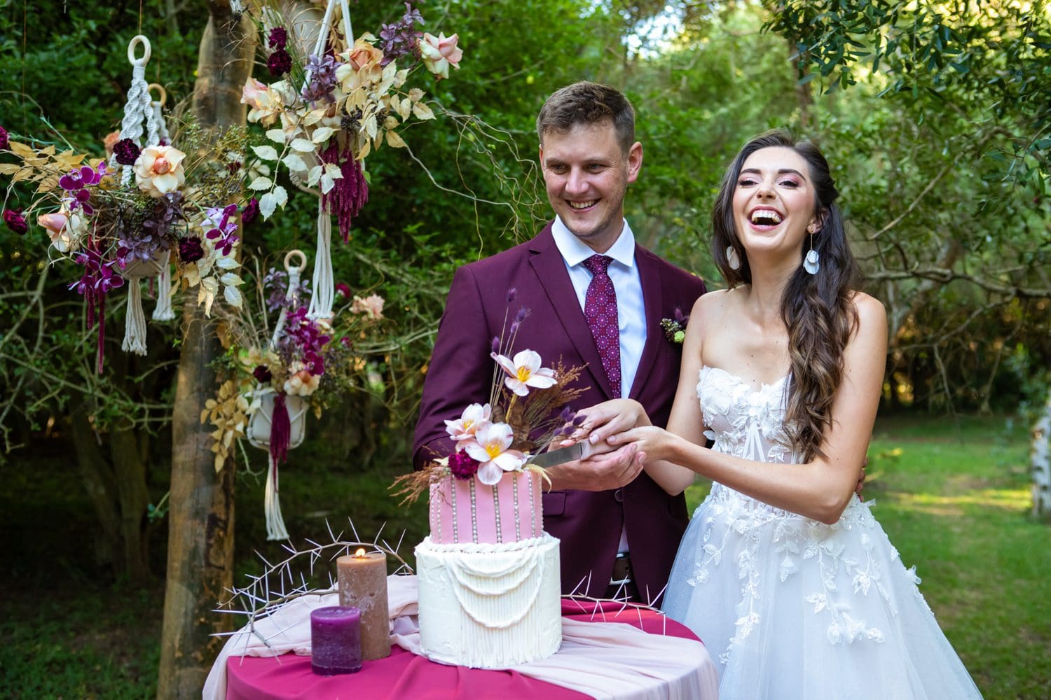 Bride and groom cutting pink and white wedding cake