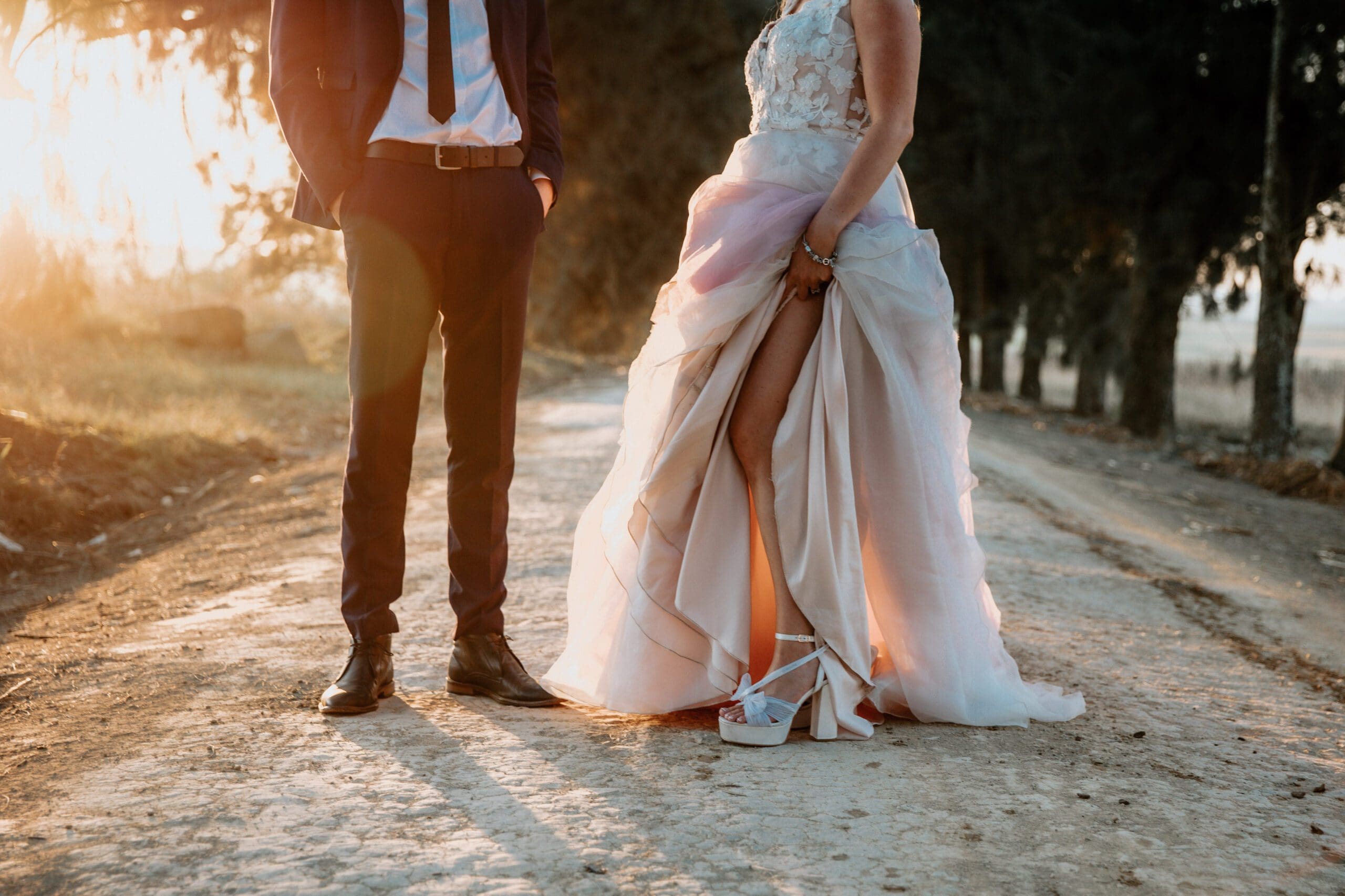 Bride and groom standing in country lane