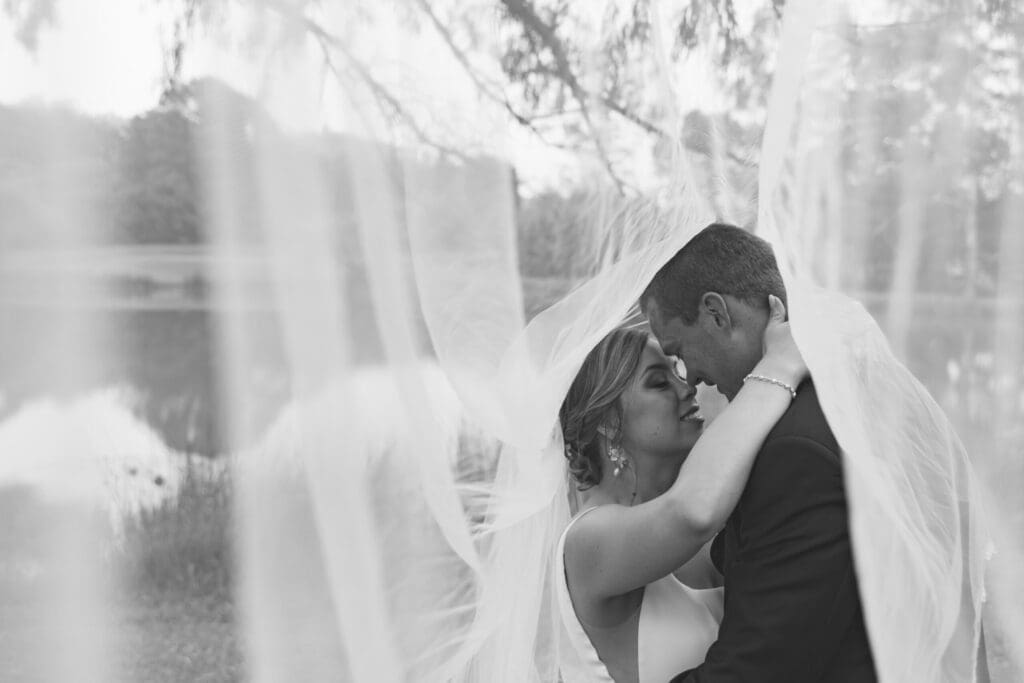 Moody black and white of bride and groom under her veil