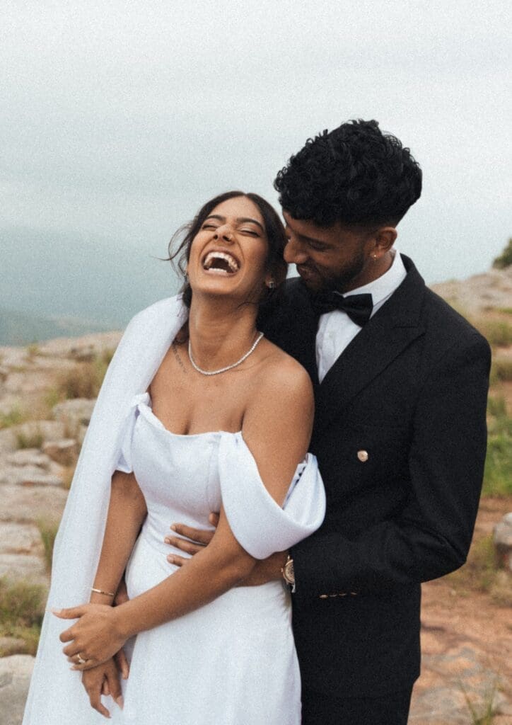 Bride laughing and leaning back into groom's chest
