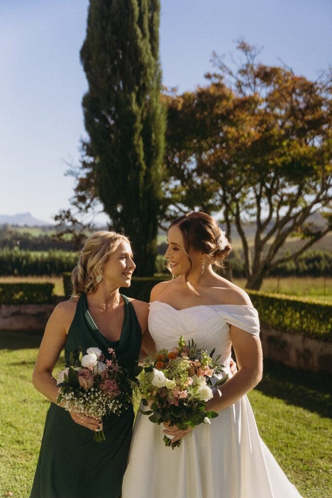 Bride standing with Bridesmaid looking at each other