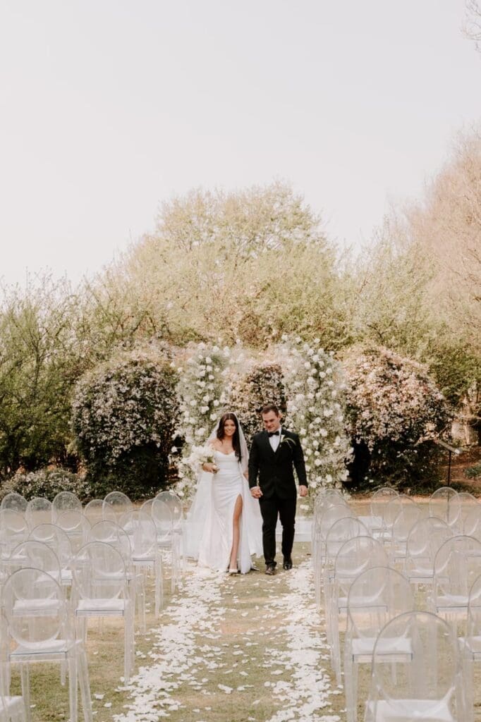 Outdoor wedding ceremony venue with white floral arch