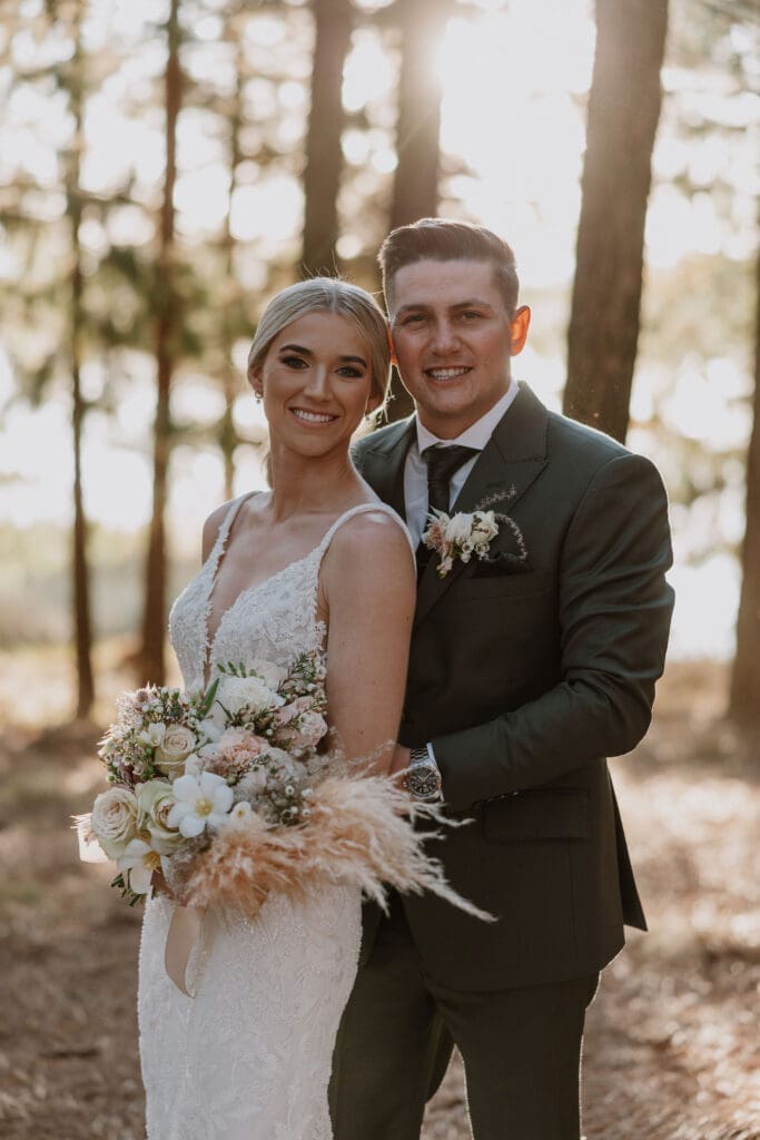 Groom standing behind bride holding bouquet