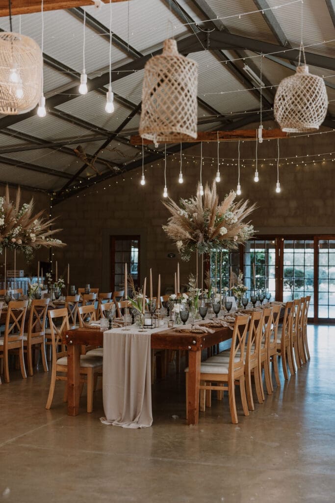 Wedding reception venue with hanging basket lights and elevated floral table displays