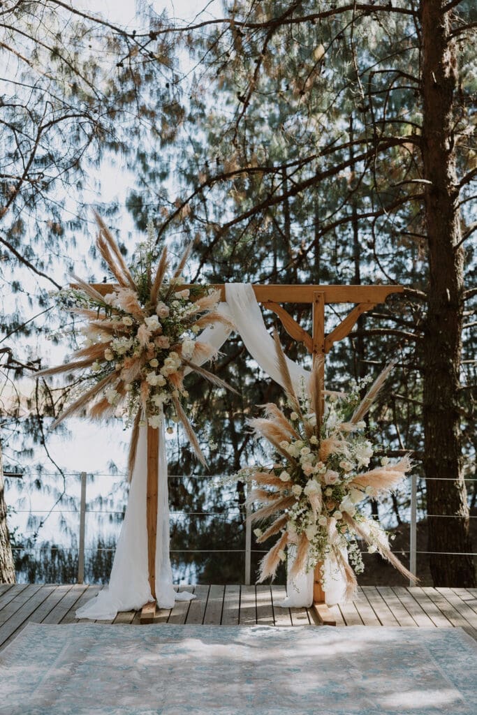 Ivory and sage green ceremony arch in forest
