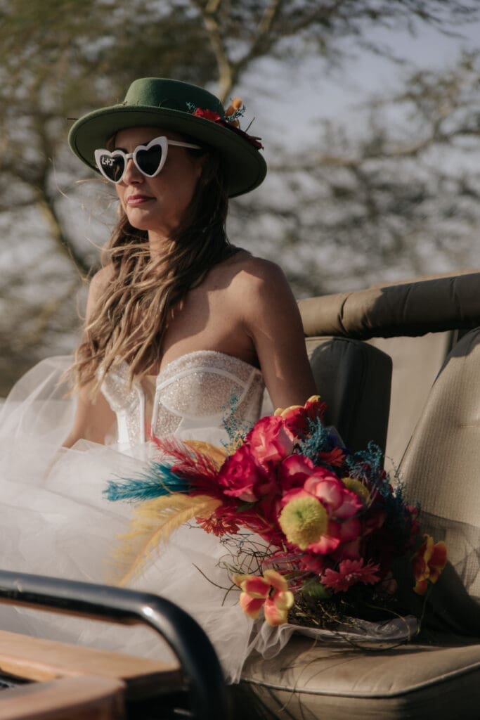 Wedfest themed bride wearing heart sunnies and holding a colourful bouquet