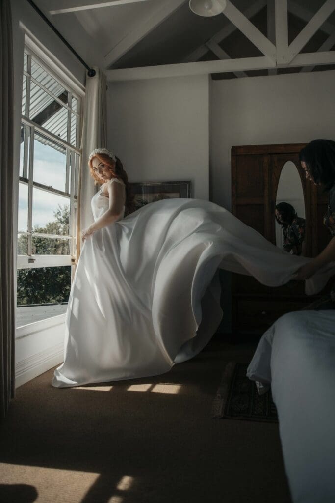 The-Knoll-Historic-Guest-Farm-KZN-Bride-getting-ready Bride getting dressed next to large window