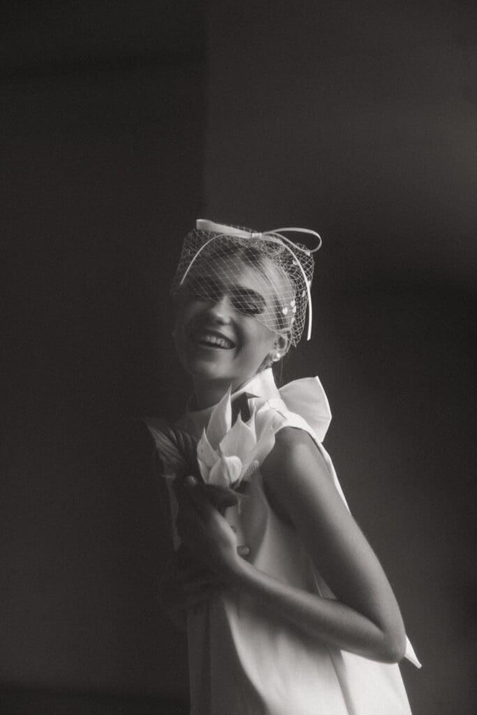 Black and white photo of bride wearing white Harlow birdcage veil by Veil Atelier