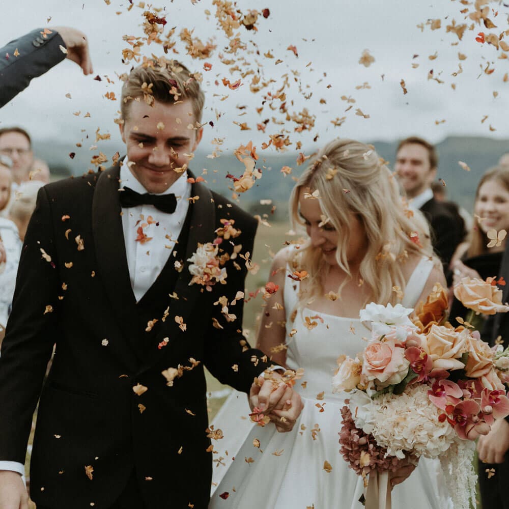 Bride-and-groom-with-petals-thrown-at-them Bride-and-groom-with-petals-thrown-at-them
