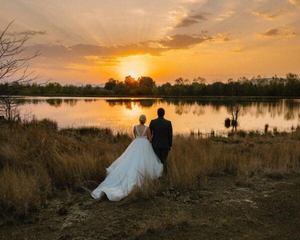 Sunset image of bride and groom looking out over the water