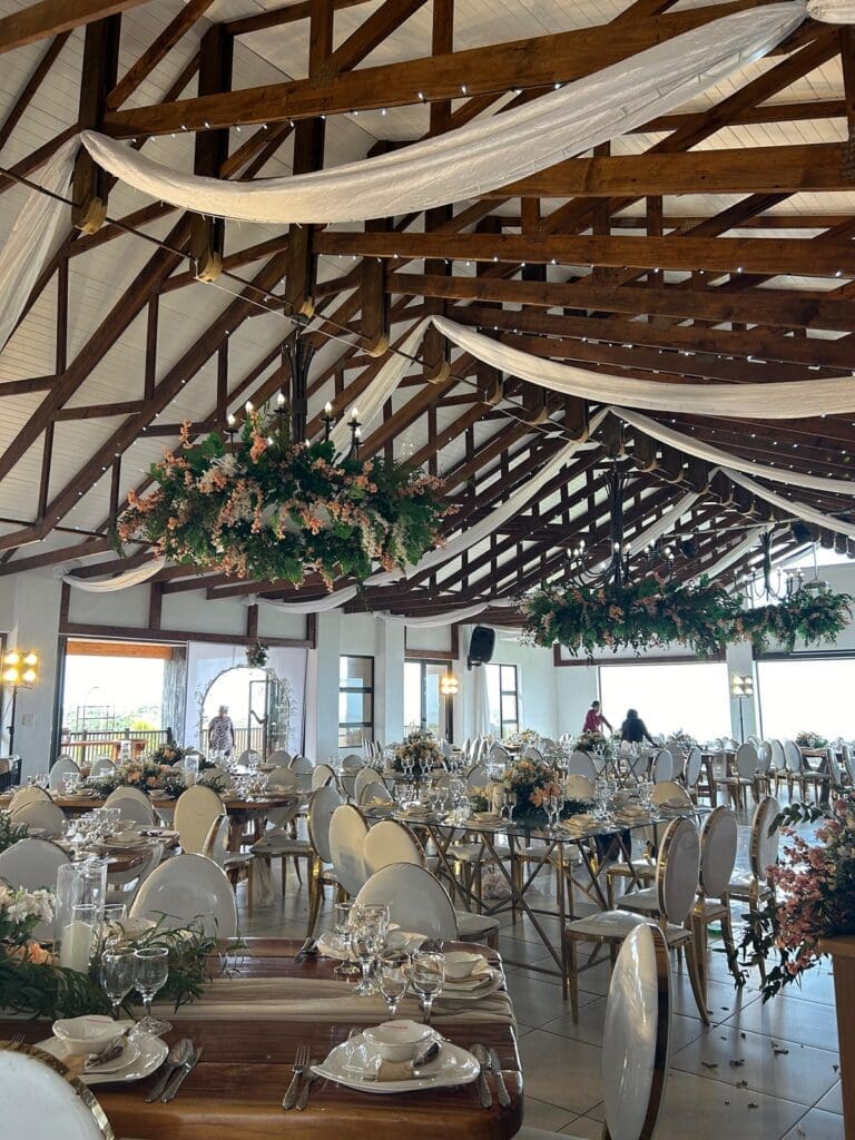Decorated reception hall at The Lazy Moose showing wooden beams on ceiling with white cascading draping