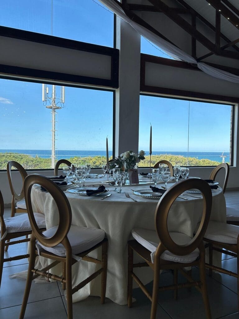 Round table setting at The Lazy Moose with ocean view in the background