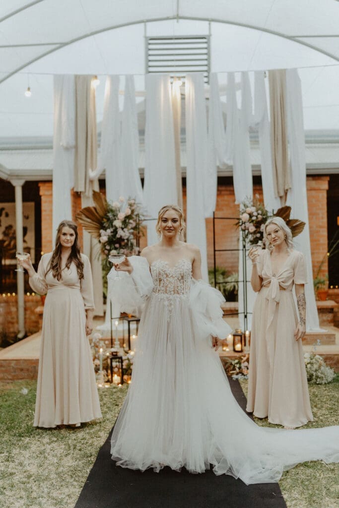 Bride and bridesmaids framed by ivory coloured wedding draping