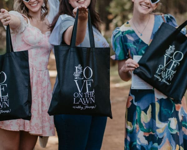 Guests at Love on the Lawn showing off their black goodie bags.