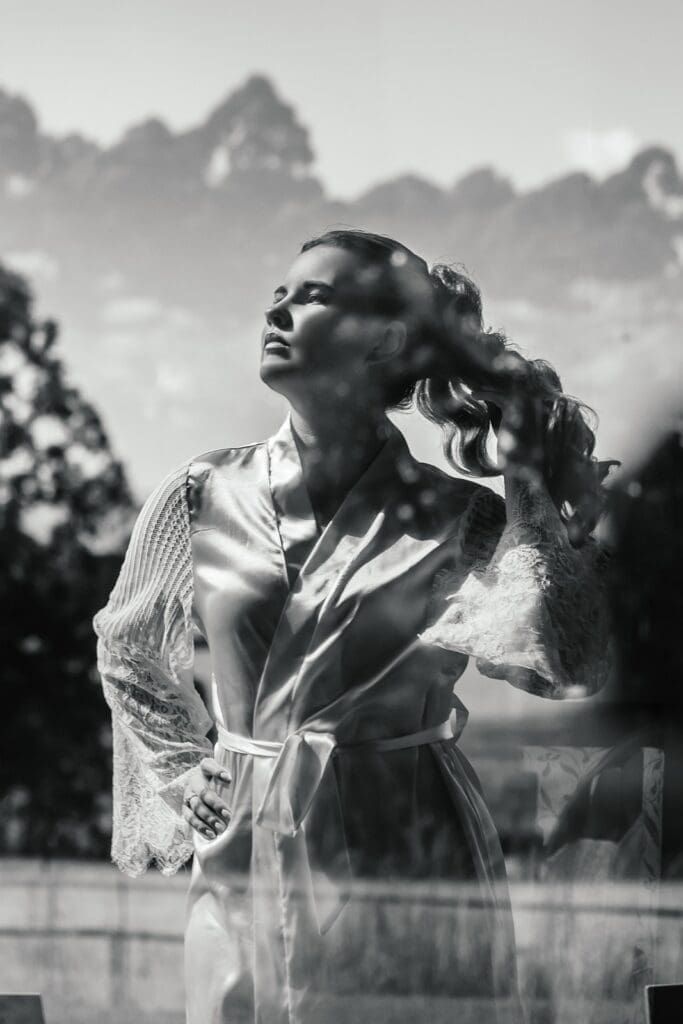 Black and white image of bride touching her hair