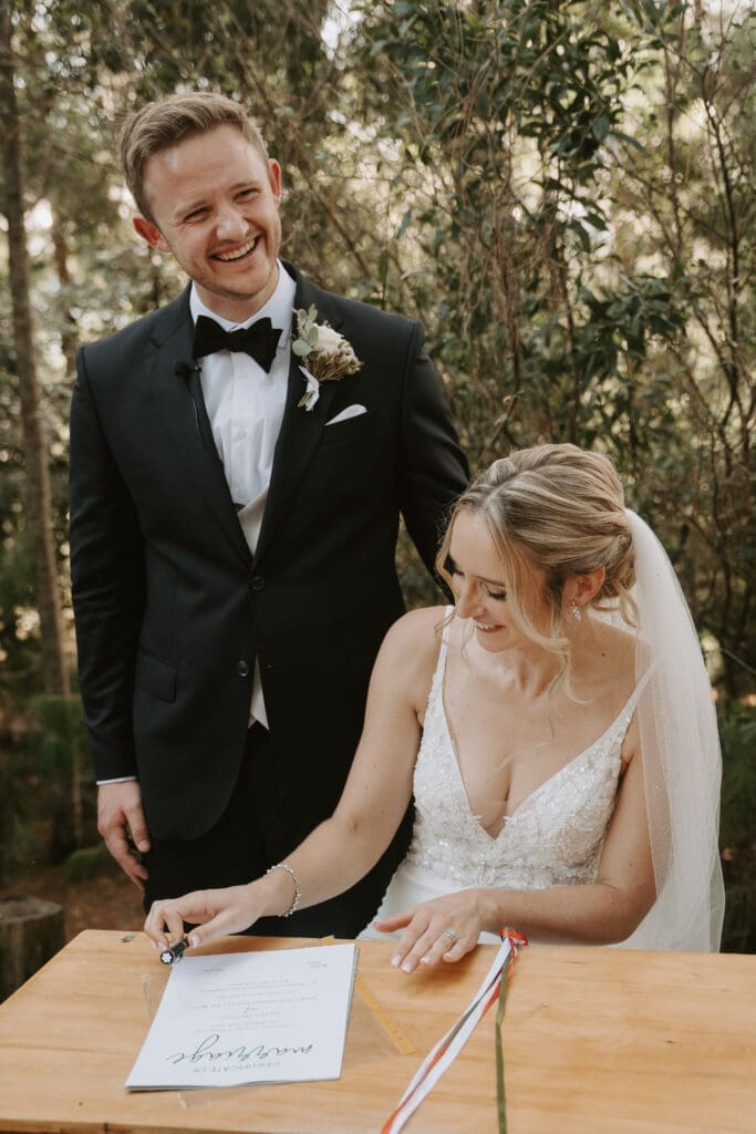 Happy bride and groom singing marriage registry