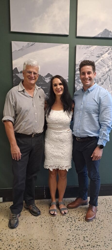 Jonathan Payne standing with married couple in office