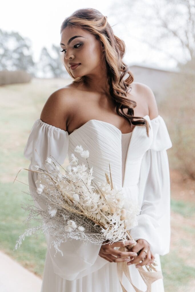 Bridal portrait - bride wearing off the shoulder wedding dress with curled hair